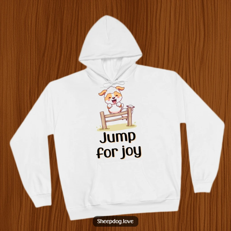 Funny sheepdog character leaping happily over a fence, surrounded by sheep, cozy hoodie design.